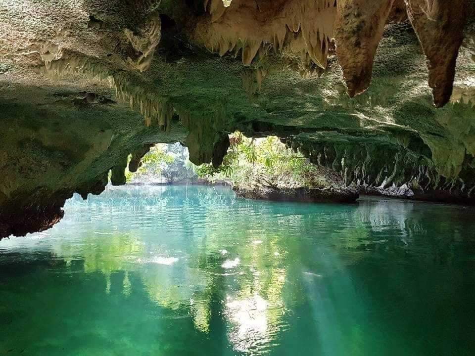 Sunlight through the limestone cave mouth at Sohoton Cove, opening onto turquoise water